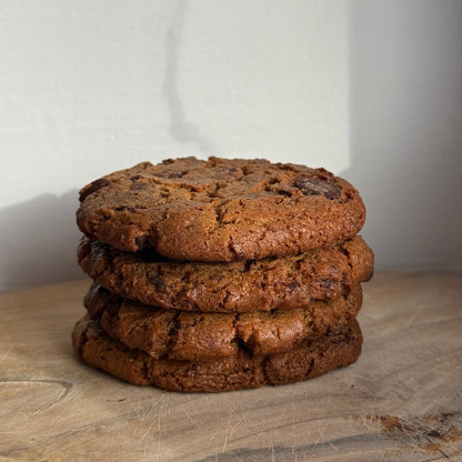 Stack of chocolate cookies on a wooden surface with a white background