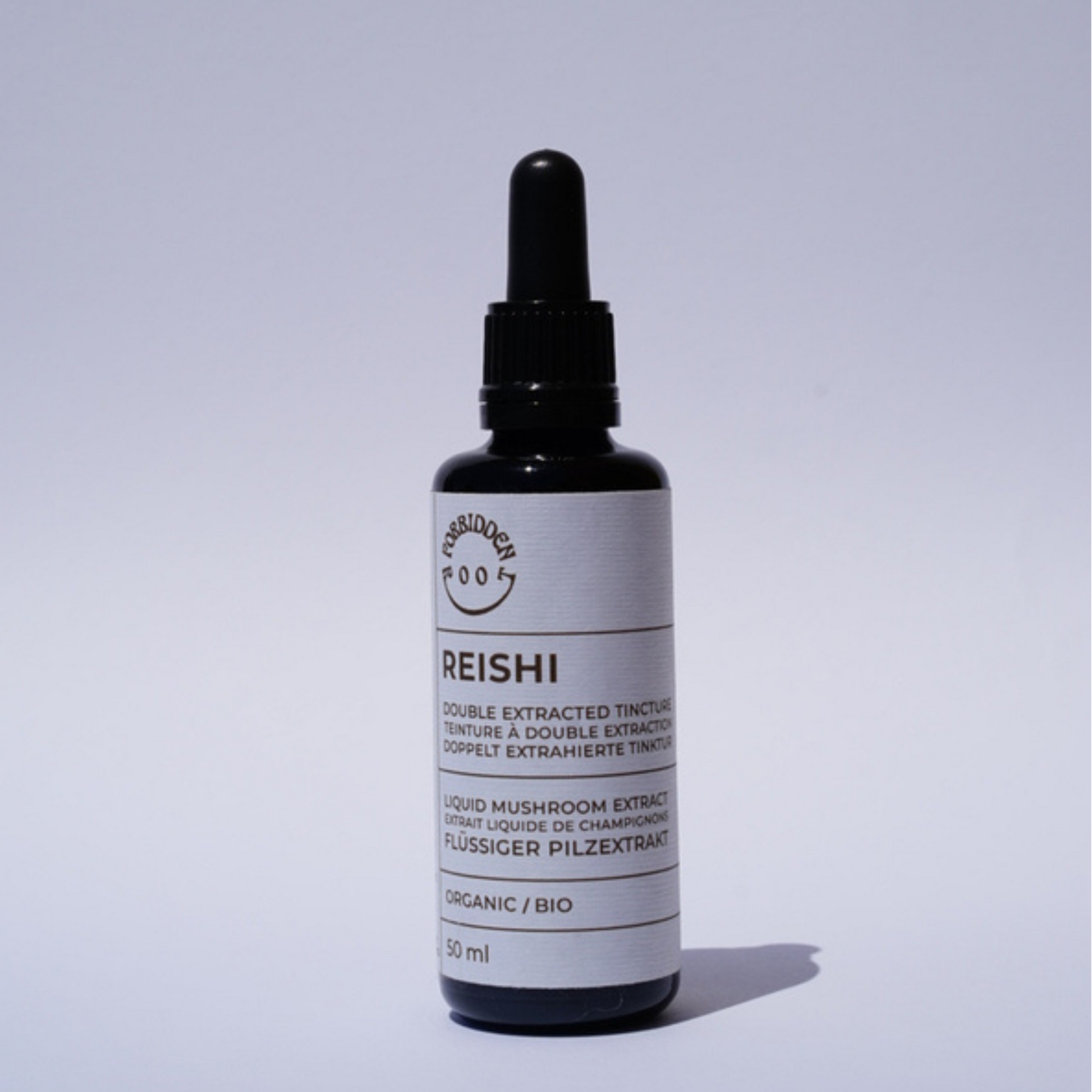 Bottle of reishi extract on a light grey background.