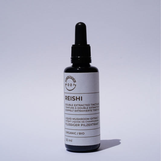 Bottle of reishi extract on a light grey background.
